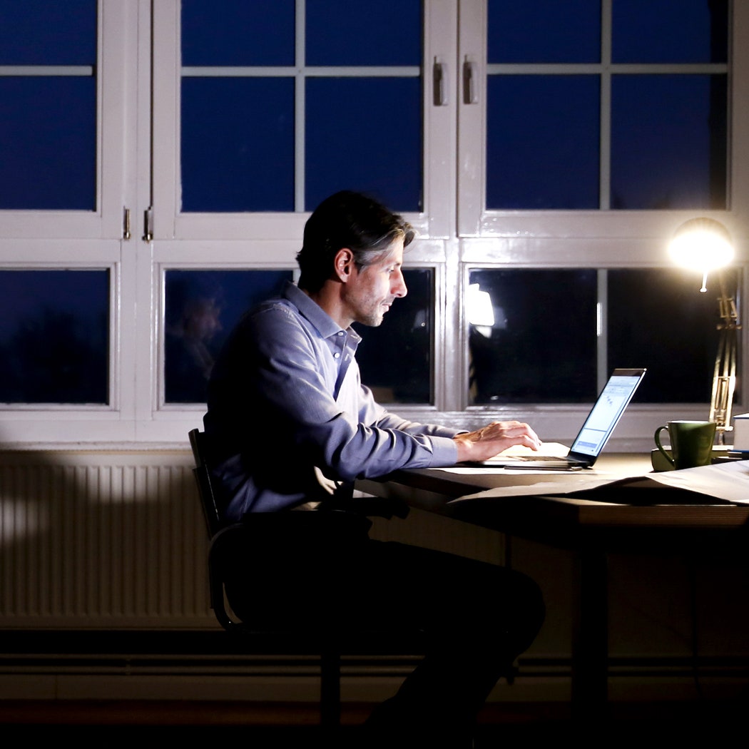 Man working on laptop at night in home office