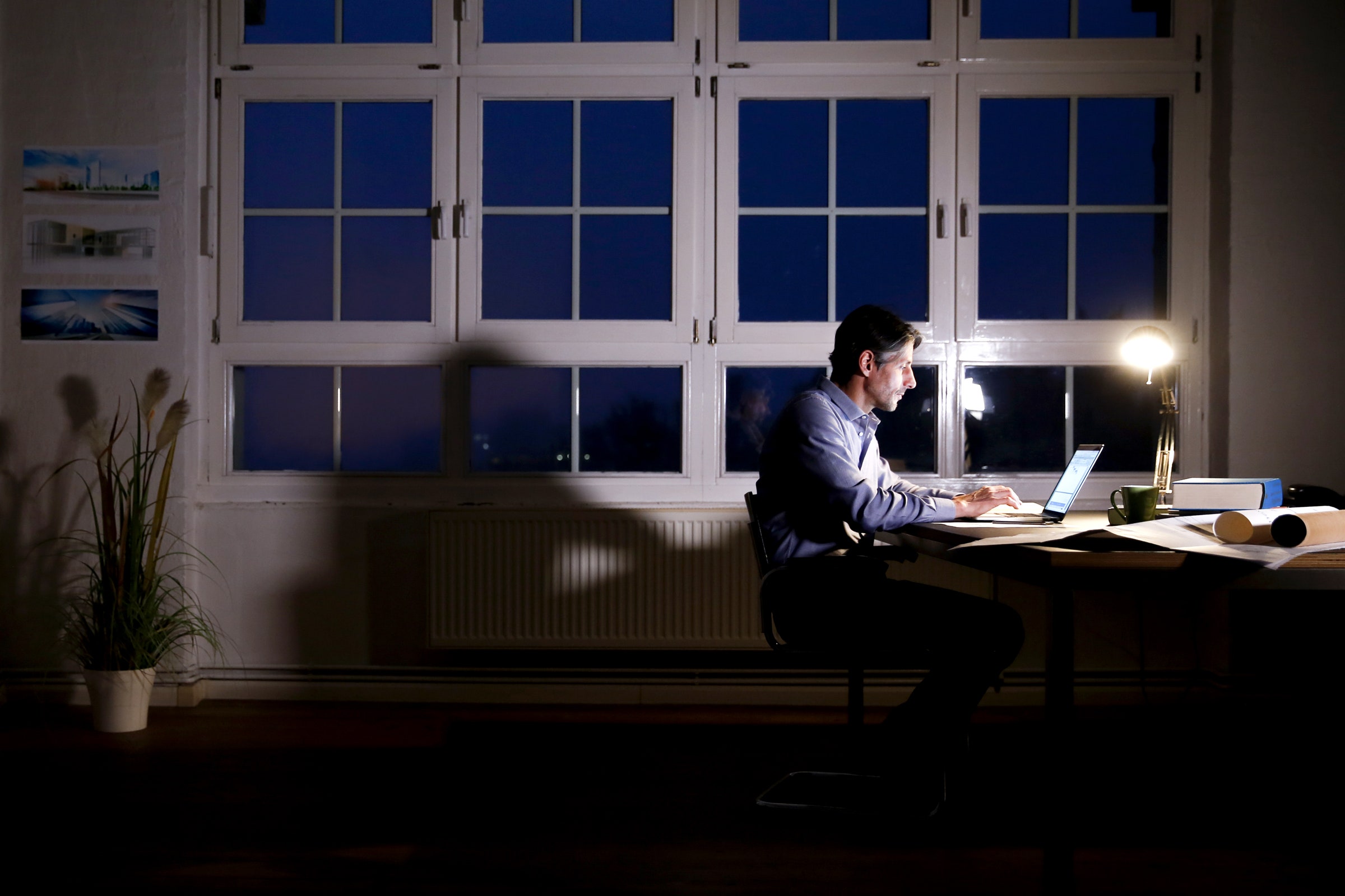 Man working on laptop at night in home office